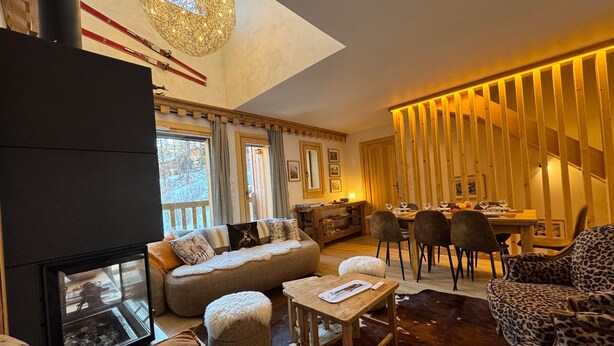 Ein gemütliches Wohnzimmer mit Kamin, Essbereich und Blick ins Freie.