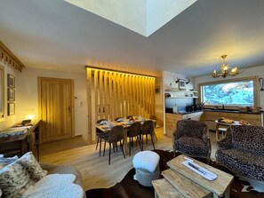 A modern interior with a dining area, kitchen, and seating. - Spacious chalet in Vars for 12 ppl (Vars)