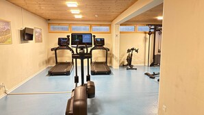 Una palestra con tapis roulant, cyclette e attrezzature per esercizi.