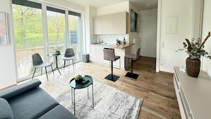 Uma sala de estar moderna com um sofá, uma mesa de centro e um espaço de jantar com cadeiras.