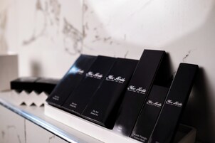 Una serie de cajas negras con texto, dispuestas sobre una superficie blanca frente a una pared con un estampado discreto.