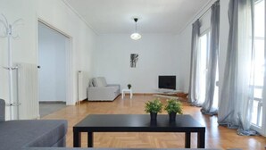 Ein stilvolles Wohnzimmer mit einer Couch, einem Couchtisch, einem Fernseher und einer Heizung.