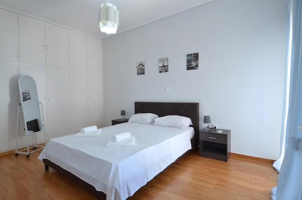 A bedroom with a bed, nightstands, a dresser, a mirror, and wall art. - Spacious minimal apartment at Chalandri (Chalandri)