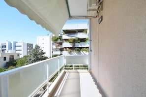 A balcony with a white railing, a tiled floor, and a view of neighboring buildings. - Spacious minimal apartment at Chalandri (Chalandri)
