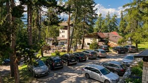 Un hôtel doté d’un parking, entouré d’arbres et offrant une vue sur la montagne.