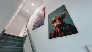 A staircase with a modern design, two artworks on the wall, and a ceiling light fixture. - Holiday Home 'Kokorey' with Private Terrace, Garden and Wi-Fi (Rellingen)