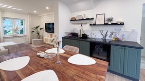 A modern kitchen with a marble backsplash, a built-in oven, and a black countertop. - Holiday Home 'Kokorey' with Private Terrace, Garden and Wi-Fi (Rellingen)