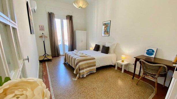 A hotel room with a bed, bedside table, chair, and a desk with a lamp. - "Keia" Pedestrianized city center, Air conditioning, Wifi (Sète)