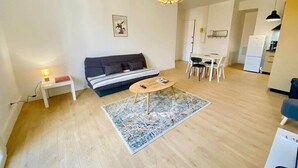 A modern living room with a sofa, a round coffee table, and a dining area with chairs. - "Keia" Pedestrianized city center, Air conditioning, Wifi (Sète)