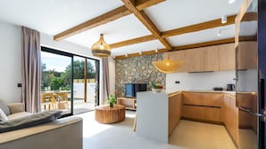 Eine moderne Küche mit Holdekor, einer Wand in Steinoptik und einem Essbereich mit einem runden Holztisch und Stühlen.