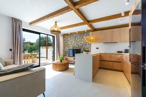 Eine moderne Küche mit Holdekor, einer Wand in Steinoptik und einem Essbereich mit einem runden Holztisch und Stühlen.