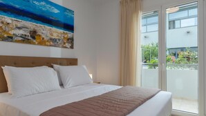 A hotel room with a bed, a large window, and a painting on the wall. - Zoelgrek Luxury Suite 2 Apartment with Shared Terrace, Wi-Fi & Air Conditioning (Iraklio)