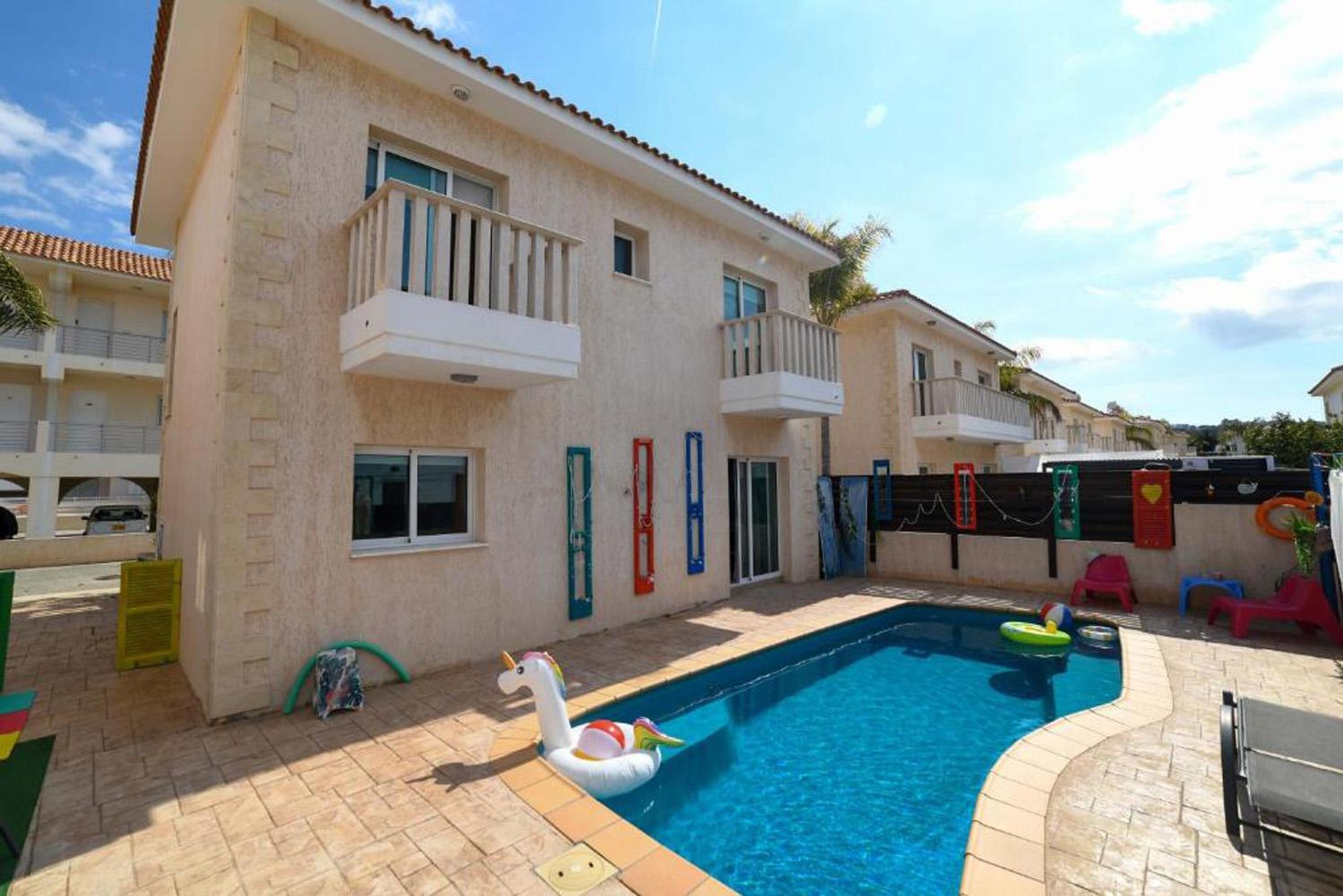 Un immeuble résidentiel doté d’une piscine, de balcons et d’un cygne flottant.
