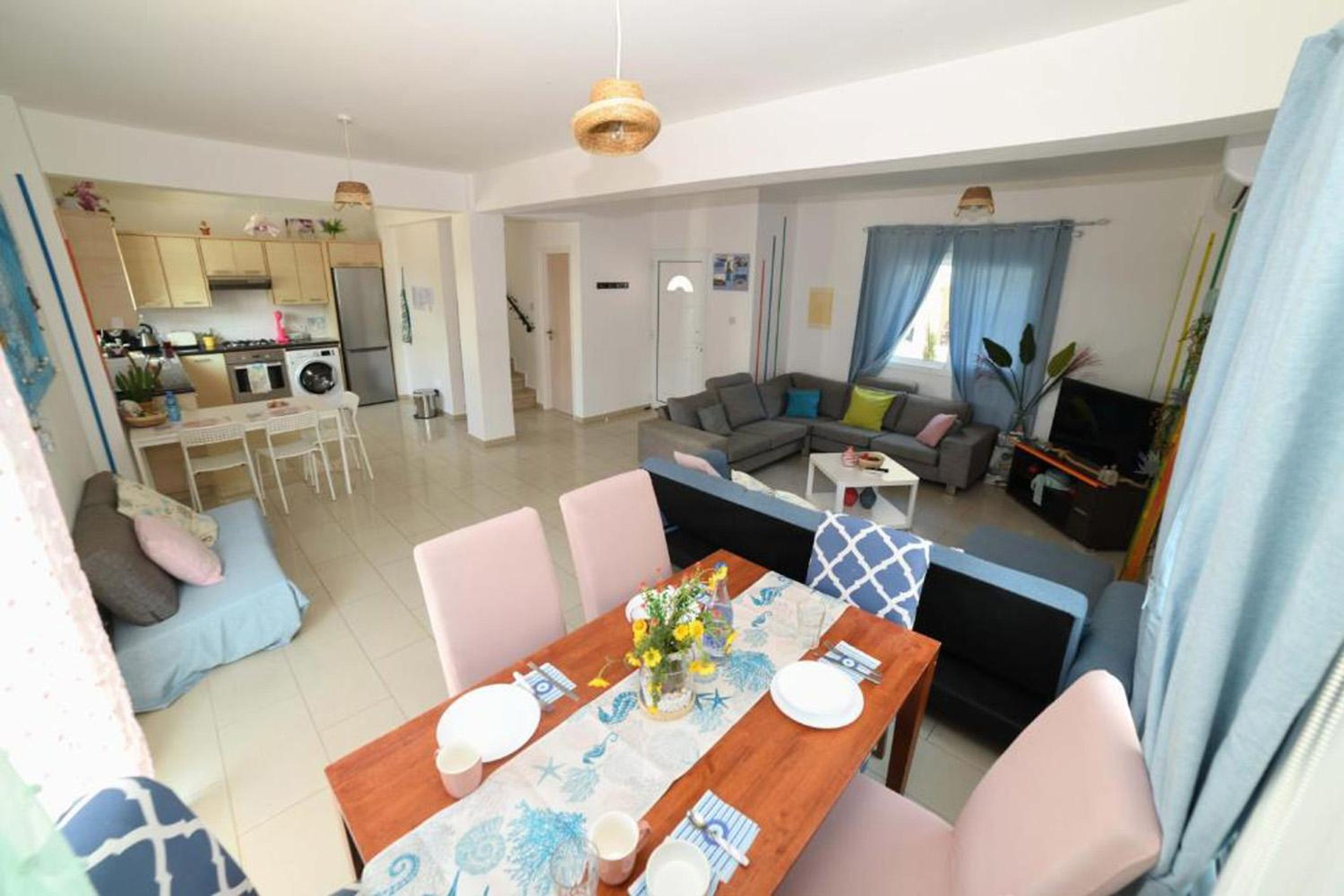 A modern apartment with a dining area, kitchen, and living room.
