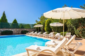 A swimming pool with lounge chairs and umbrellas. - Four Seasons Villa in Oludeniz (Fethiye)