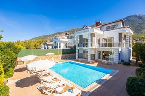 A modern two-story villa with a swimming pool, outdoor seating, and a mountain backdrop. - Four Seasons Villa in Oludeniz (Fethiye)