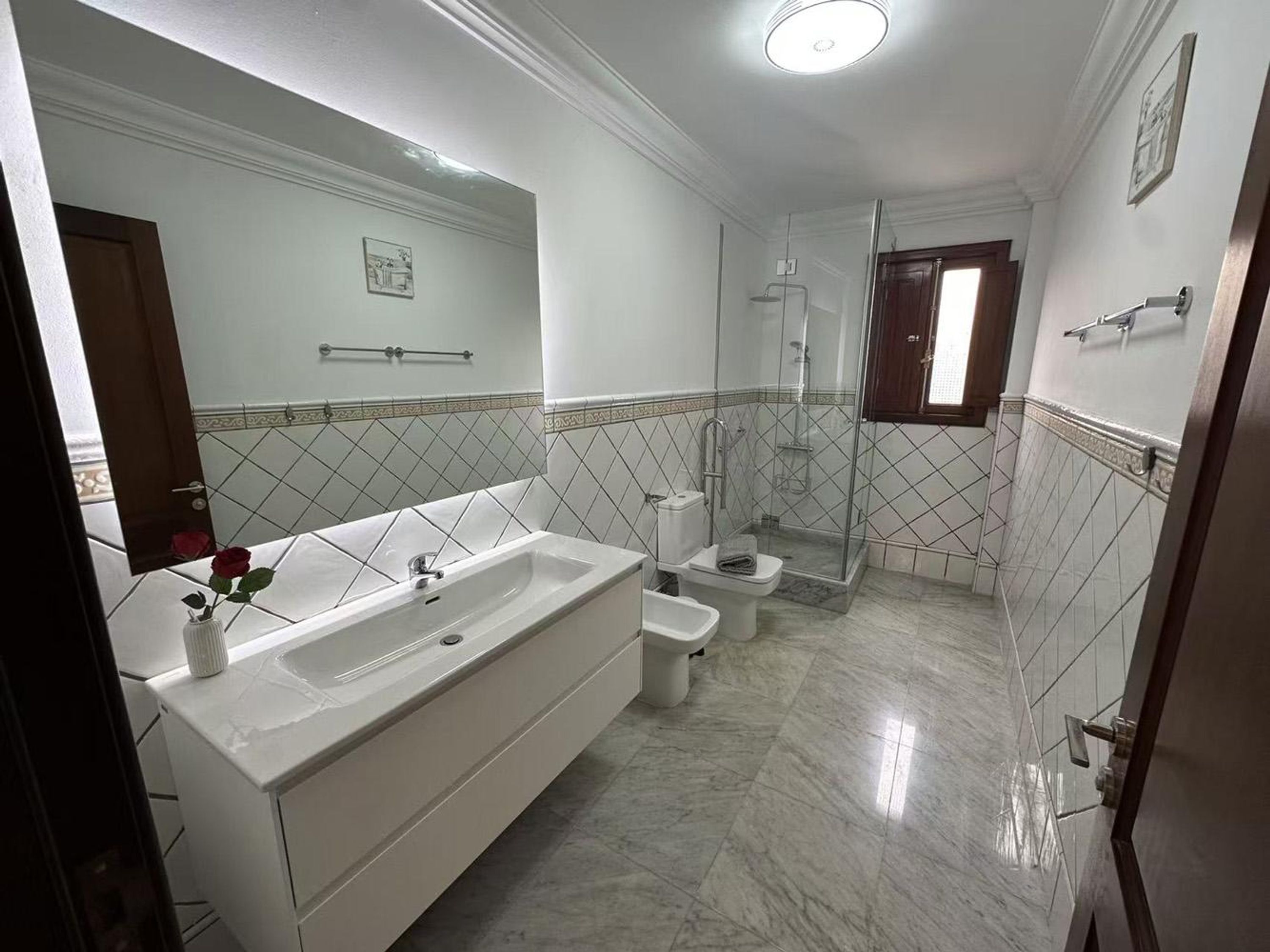 Un bany modern amb una banyera gran, dutxa i vàter.