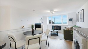 Ett modernt kök med matplats, tvättmaskin och ett stort fönster med fin utsikt.