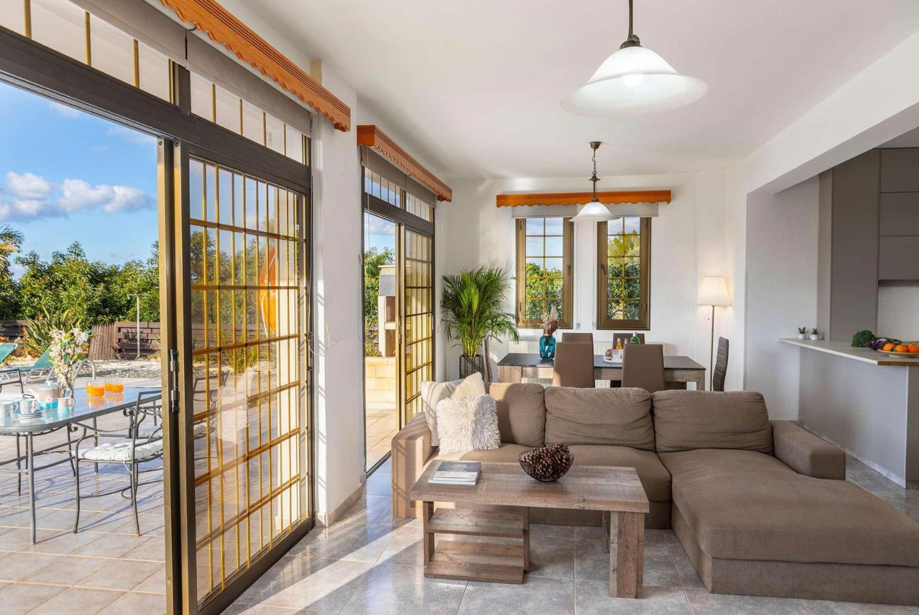 A spacious living area with a large sliding glass door, a sofa, a coffee table, and a dining area.