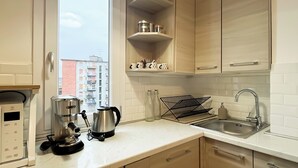 Eine moderne Küche mit Kaffeemaschine, Wasserkocher und Spüle.