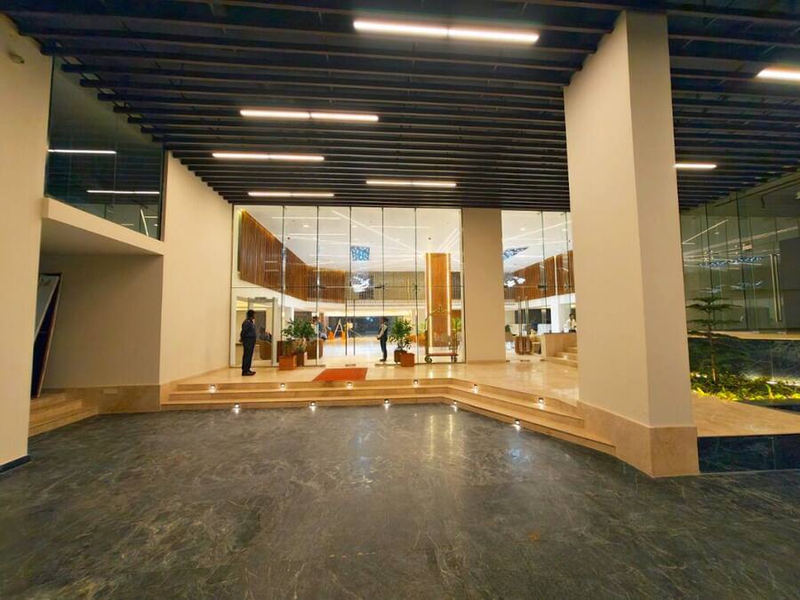 A spacious lobby with a high ceiling, large windows, and a central seating area.