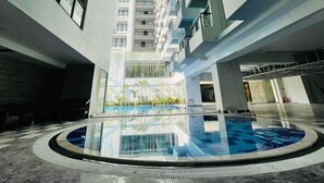 A modern building with a central atrium, a pool, and multiple balconies. - Hotel Grand Pacific (Cox's Bazar)