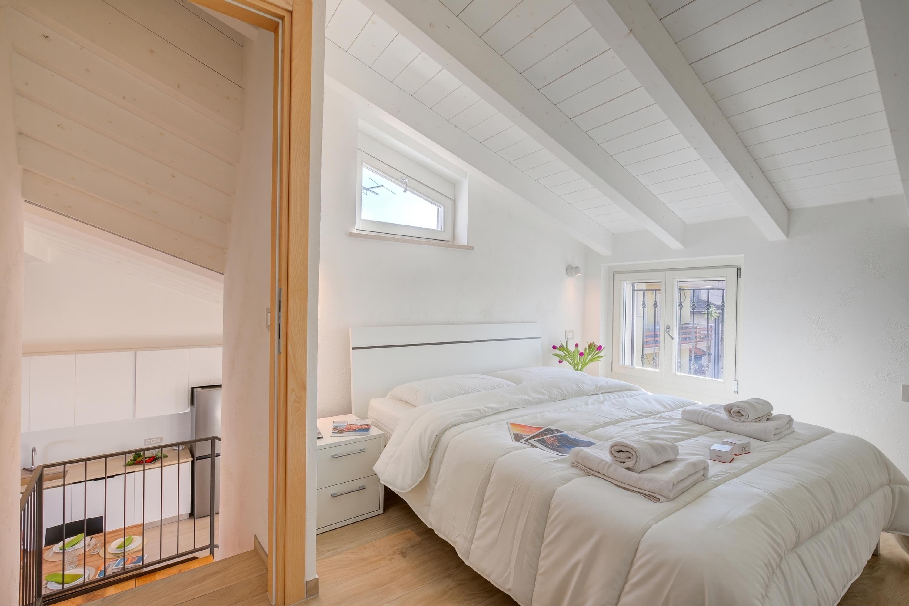 A bedroom with a bed, nightstand, and a window with a view.