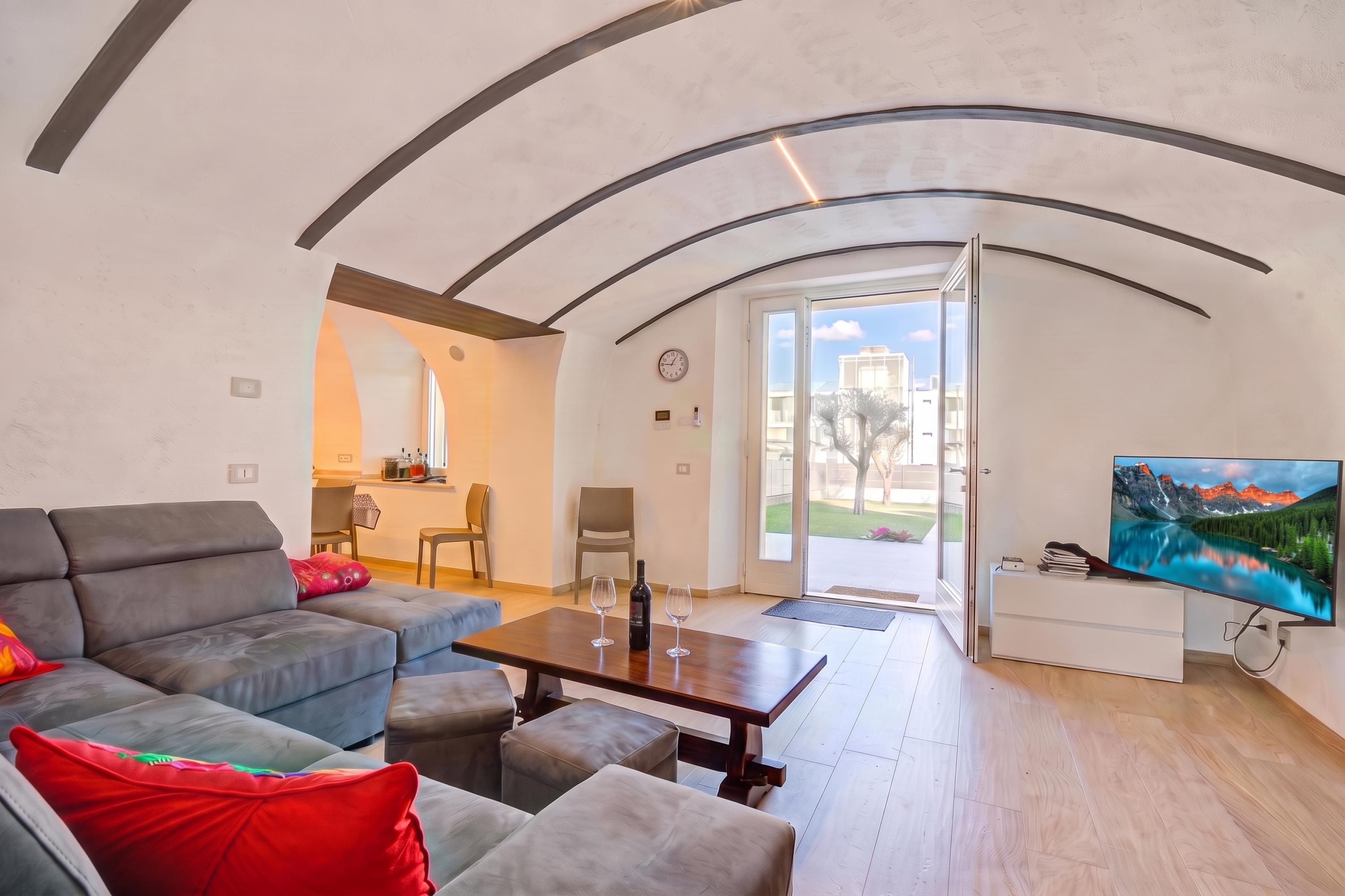 A modern living room with a sofa, a coffee table, and a television.
