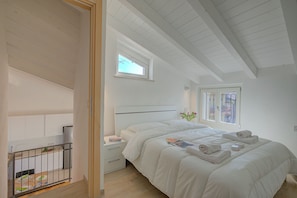 A bedroom with a bed, nightstands, a window, and a view of the outside. - Peschiera Apartments Near The Lake (Peschiera del Garda)