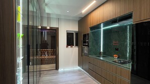 Eine moderne Küche mit Holzschränken, einer Glasrückwand und einem Edelstahlkühlschrank.
