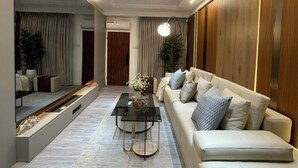 Ein modernes Wohnzimmer mit einer Couch, einem Couchtisch und einem großen Spiegel.