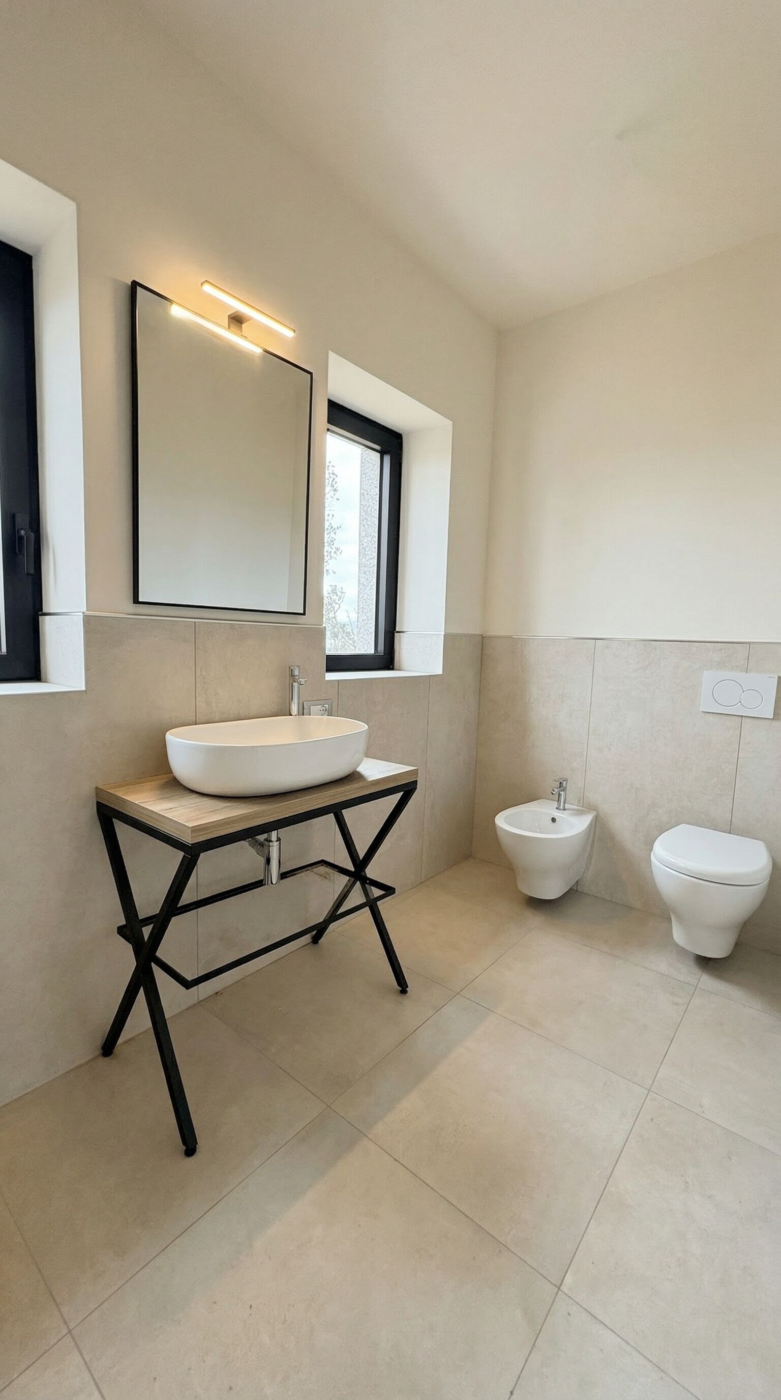 Une salle de bain moderne avec un lavabo blanc, un bidet et des toilettes.