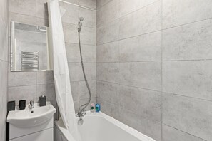 Een bad/douchecombinatie, een diep bad, een haardroger, handdoeken