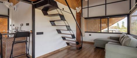 Un interior moderno con una escalera de madera, un sofá y un comedor.