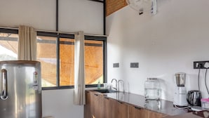 Una cucina moderna con frigorifero integrato, lavello, macchina del caffè e ventilatore.