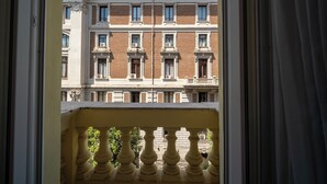 Vista di un edificio con un balcone, caratterizzato da una ringhiera e un cielo sereno.