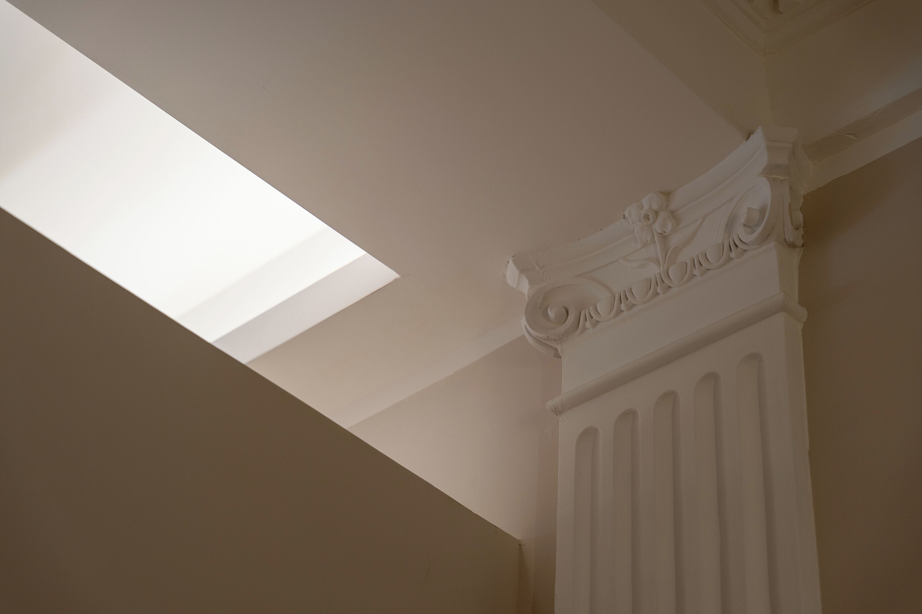 A skylight in a room with a decorative ceiling and a radiator.