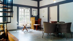 Una habitació amb taula de menjador, cadires, un rellotge i una porta.