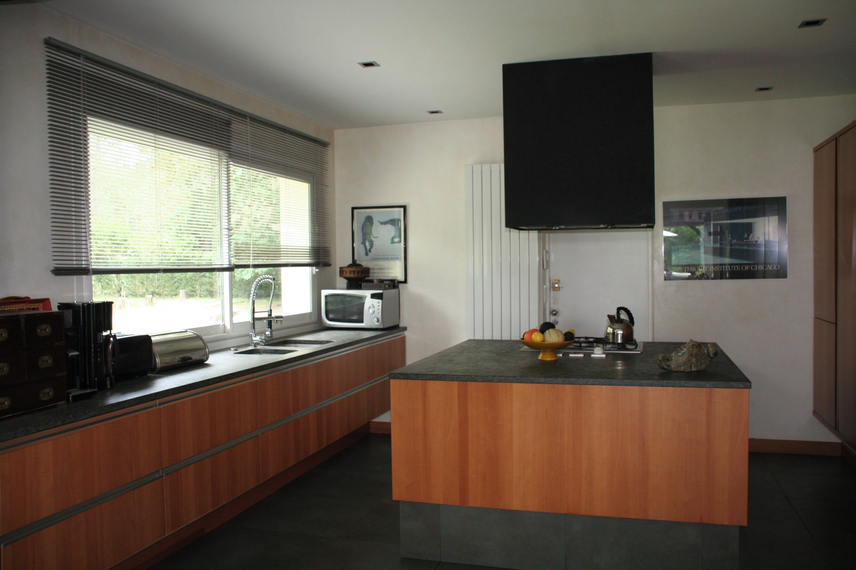 Una cocina moderna con una isla central, un microondas y un lavamanos.