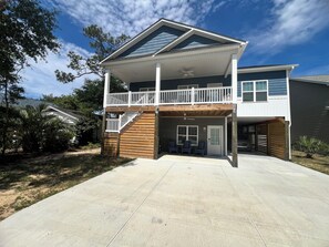 Ein zweistöckiges Haus mit Balkon, überdachter Terrasse und Garage.