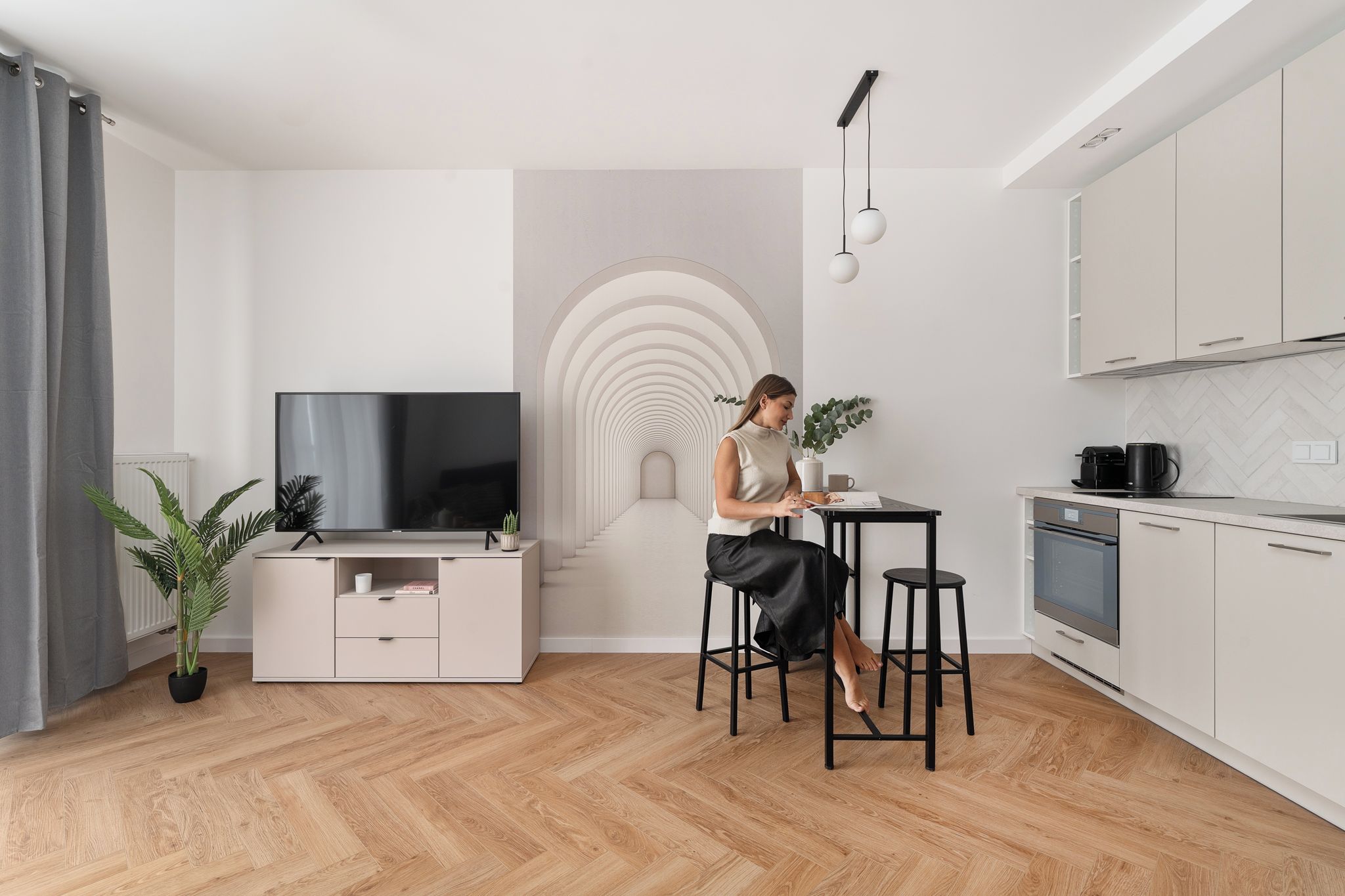 Una cocina moderna con comedor, televisor y una escalera de diseño único.