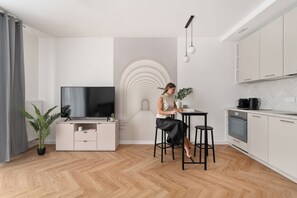 Cozinha moderna com área de jantar, televisão e escada de design único.