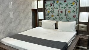 Un dormitorio moderno con una cama grande, paredes de mármol y un cabecero floral.