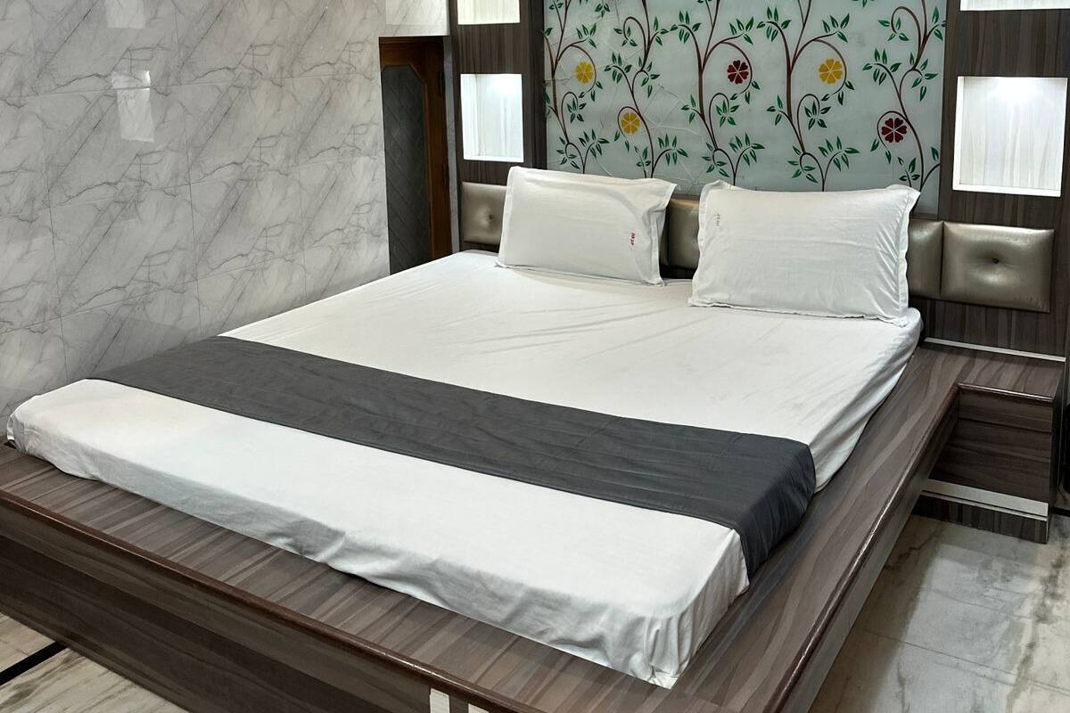 A modern bedroom with a large bed, marble walls, and a floral headboard.