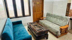 Una sala de estar con un sofá, una mesa de centro y una puerta de madera con el número 113.