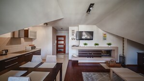 A modern loft apartment with a kitchen, living area, and a fireplace.