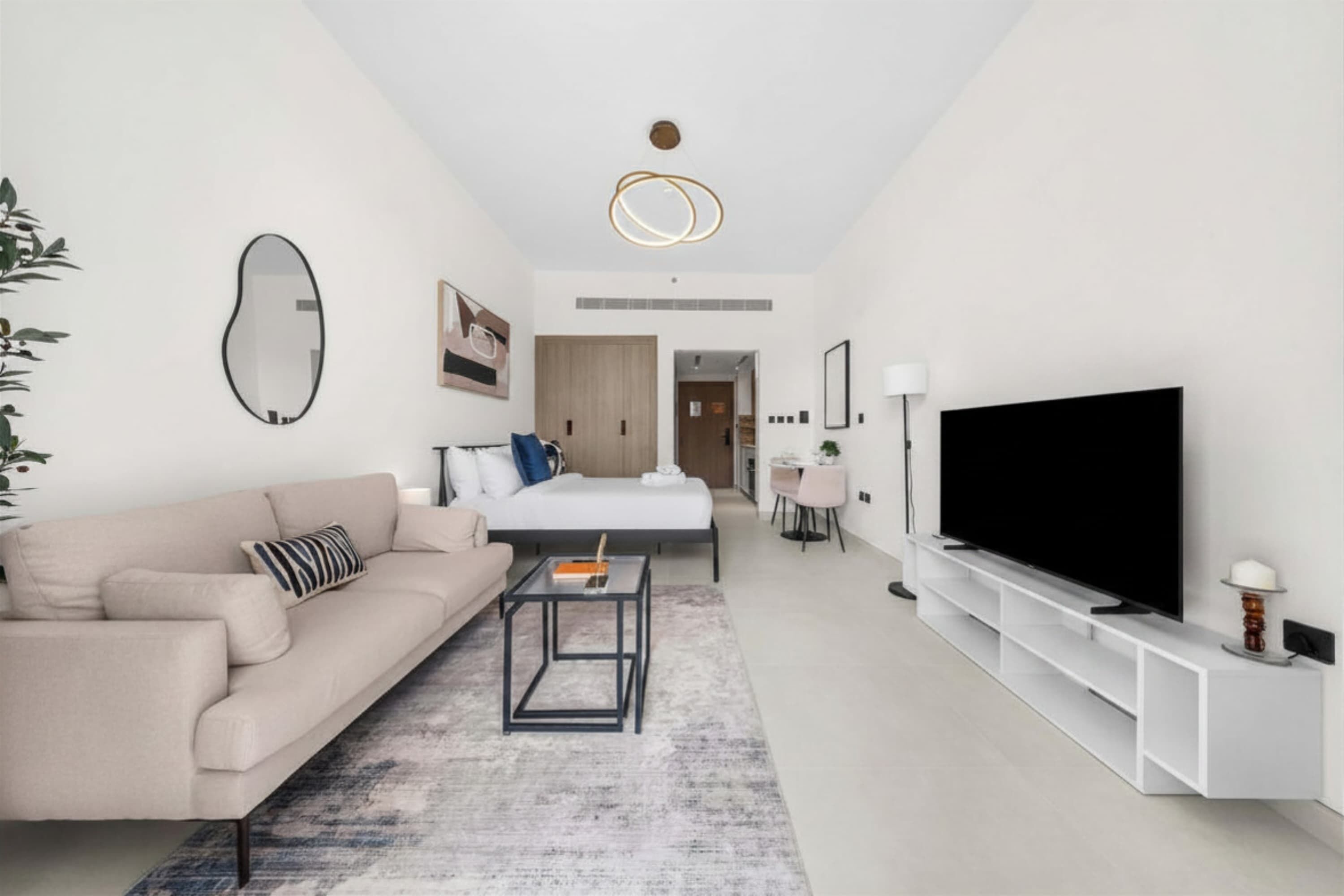 A modern living room with a sofa, coffee table, and a flat-screen TV.