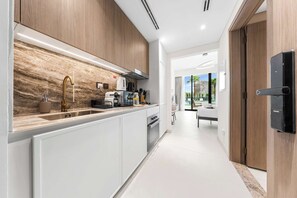 A modern kitchen with a marble backsplash, stainless steel appliances, and a wooden cabinet. - Free housekeeping visits during your stay - StayShort - Comfortable Studio Stay in Arjan Sleeps 2 with  Balcony (Arjan)