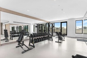 A modern gym with exercise equipment, mirrors, and large windows. - Free housekeeping visits during your stay - StayShort - Comfortable Studio Stay in Arjan Sleeps 2 with  Balcony (Arjan)