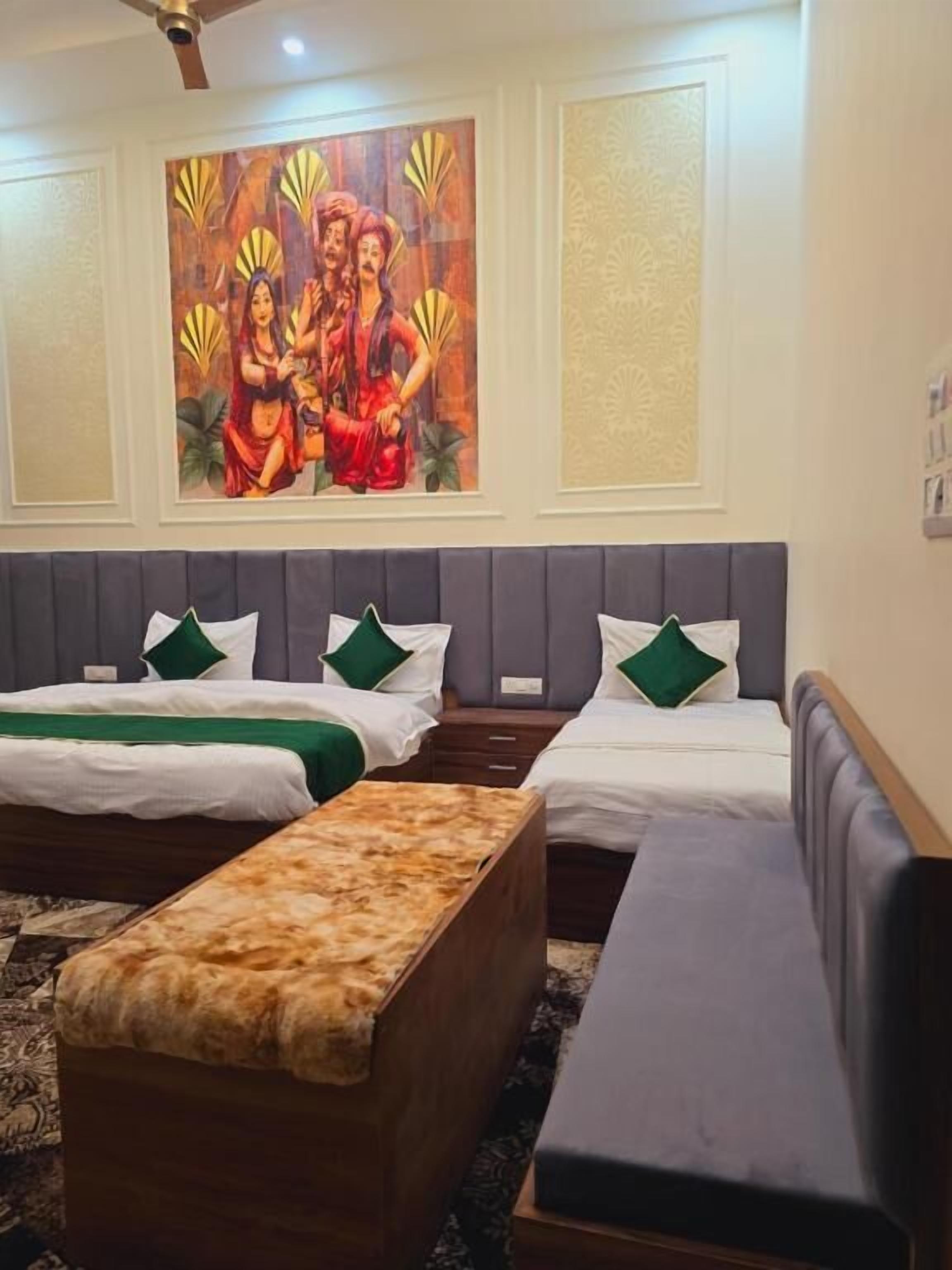 Une chambre d’hôtel avec deux lits, un banc, un tableau et une moquette à motifs.